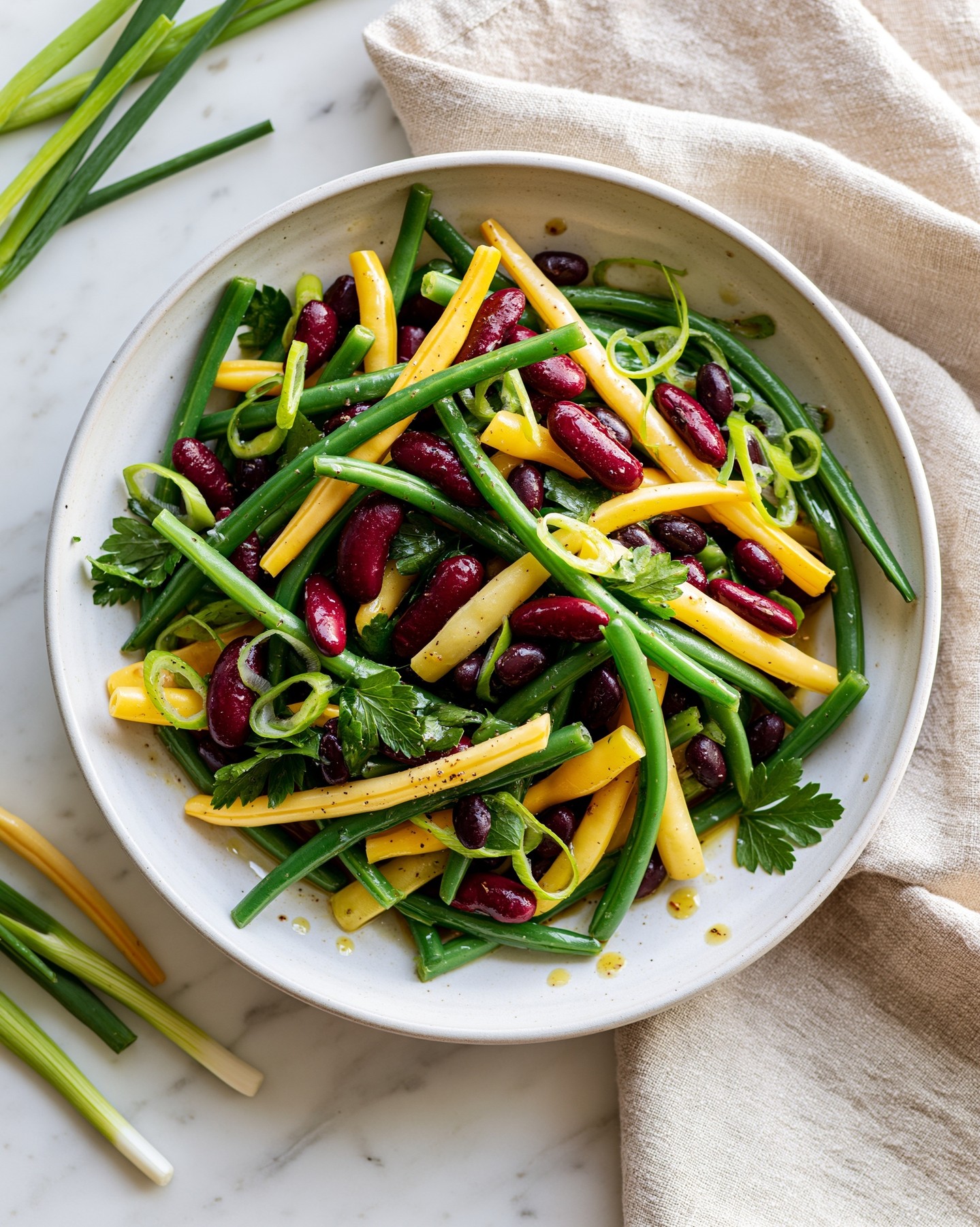 🫘🥗 Sałatka Full of Beans - z trzema rodzajami fasoli i fasolką szparagową ✨
Nazwa nawiązuje do angielskiego idiomu full of beans - czyli „pełen energii”, co idealnie pasuje do tej sałatki. Dużo białka i błonnika. Świetnie sprawdzi się jako sycący lunch, lekka kolacja albo dodatek do dań z grilla. 🥗 💚Składniki na 6 porcji:🌱 200 g zielonej fasolki szparagowej (poza sezonem z mrożonki)
🌱 200 g żółtej fasolki szparagowej (poza sezonem z mrożonki)
🌱 4 dymki (ze szczypiorem)
🌱 1 szklanka czerwonej fasoli z puszki, odsączonej i opłukanej
🌱 1 szklanka czarnej fasoli z puszki, odsączonej i opłukanej
🌱 1 szklanka ciecierzycy z puszki, odsączonej i opłukanej
🌱 3 łyżki posiekanej natki pietruszki
🌱 sól i świeżo mielony pieprzSos:
🌱 3 łyżki octu z czerwonego wina
🌱 2 łyżeczki musztardy Dijon
🌱 1–2 łyżeczki ksylitolu (lub kilka kropli stewii)
🌱 sól i świeżo mielony pieprz
🌱 1/3 szklanki oliwy z oliwek (opcjonalnie)1️⃣ Fasolkę szparagową oczyść, przekrój na pół i ugotuj przez 3–4 minuty w osolonym wrzątku. Następnie przelej zimną wodą i odcedź.
2️⃣ Dymkę pokrój w cienkie plasterki.
3️⃣ Do dużej miski przełóż fasolkę szparagową, czerwoną fasolę, czarną fasolę, ciecierzycę oraz dymkę.
4️⃣ W miseczce wymieszaj ocet, musztardę, ksylitol, sól i pieprz. Jeśli przygotowujesz wersję z oliwą, dodawaj ją cienkim strumieniem, cały czas mieszając.
5️⃣ Polej sałatkę sosem i delikatnie wymieszaj.
6️⃣ Przed podaniem posyp posiekaną natką pietruszki.Pasuje do 1. i 3. fazy Diety Przyspieszającej Metabolizm.
.
.
.
#szybkaprzemiana #sałatka #zdroweprze #dieta #fitprzepis